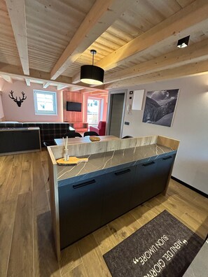 A modern kitchen with a marble countertop, wooden cabinets, and a black ceiling fan. - Apartment '1 Trilocale' with Mountain View, Balcony and Wi-Fi (Livigno)