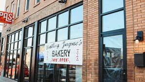 Un edificio de ladrillo con ventanas amplias y un letrero que indica Bailey Jayne's Bakery.