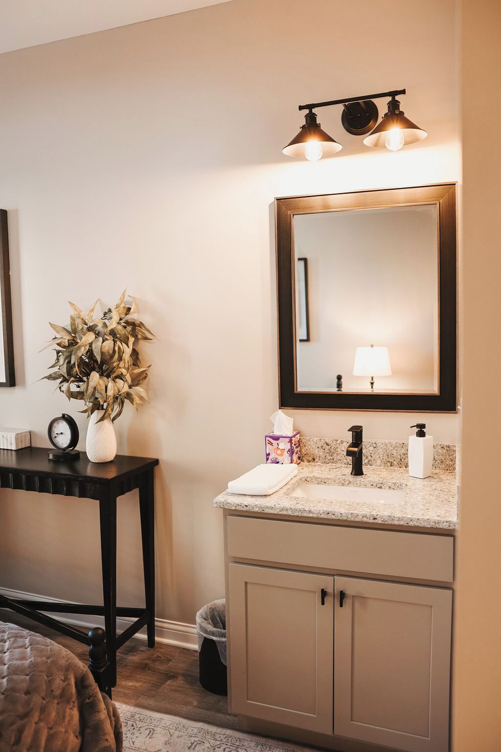 A bathroom with a vanity, a mirror, a sink, and a towel.