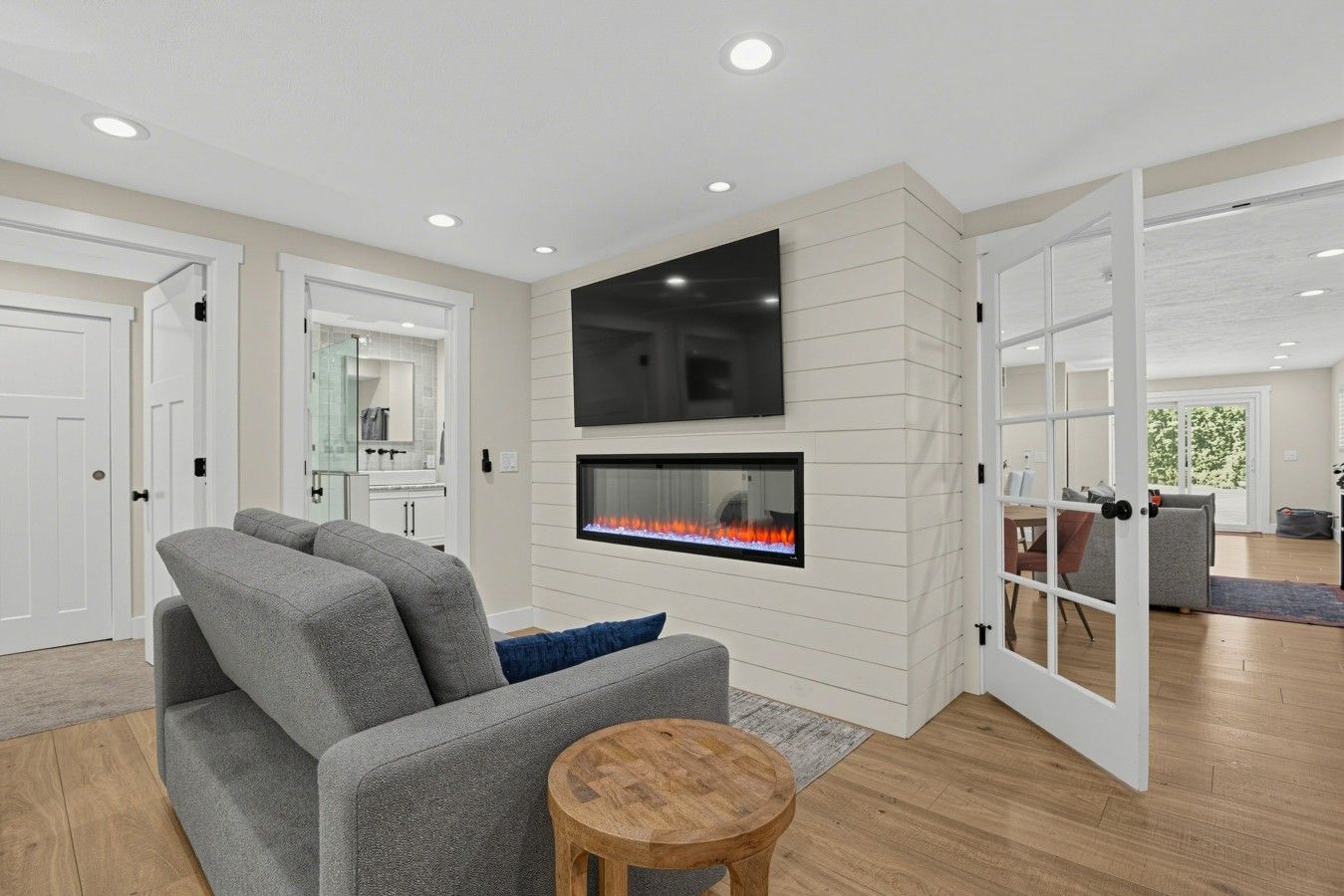 Una sala moderna con chimenea, televisor de pantalla plana y sofá gris.