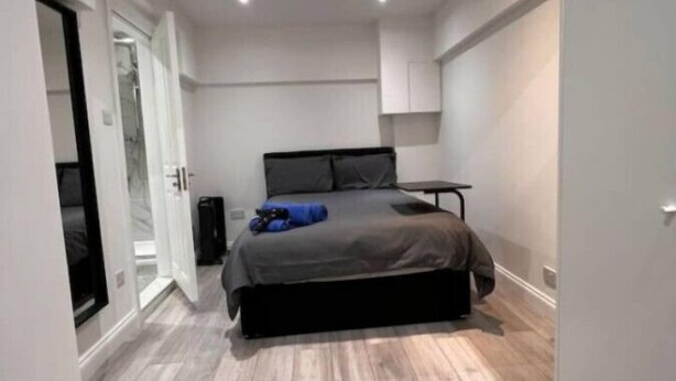 A modern bedroom with a bed, a wardrobe, and a door leading to another room. - Central London, Zone 2, Studio Flat (Greater London)