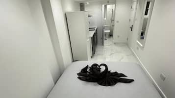 Una habitación de hotel con cama, baño y kitchenette.
