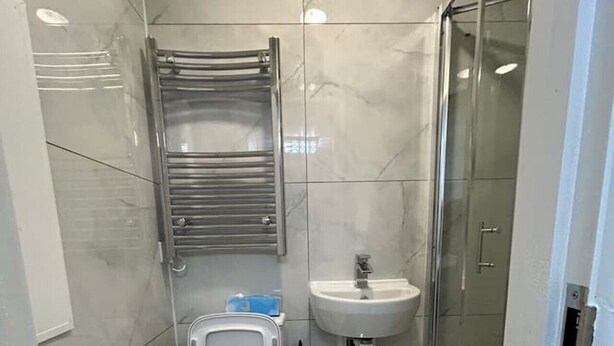 A modern bathroom with a toilet, bidet, sink, and glass shower enclosure. - Marylebone Room + bathroom (Greater London)