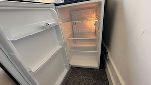 An interior of a refrigerator with multiple shelves and a freezer compartment. - Baker Street room moments away (Greater London)
