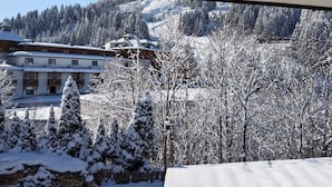 A snow-covered landscape with a building featuring a wooden facade and multiple windows. - Arrive.feel good.enjoy (Wagrain)