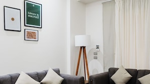 Un salon moderne avec deux canapés gris, une table basse en bois et un lampadaire.