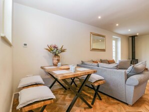 Un salon moderne avec un canapé, une table à manger en bois et un vase décoratif.