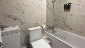 Ein modernes Badezimmer mit einer Glasdusche, einer Toilette und einem Waschbecken.