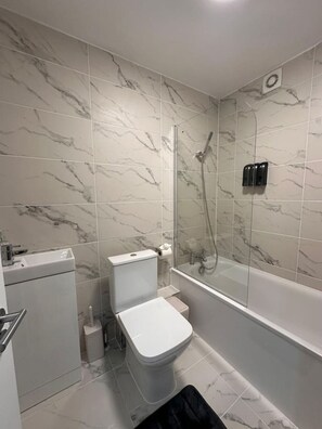 A modern bathroom with a glass-enclosed shower, a toilet, and a sink. - Oxford street minutes away ! (Greater London)