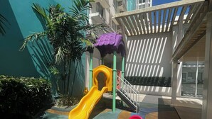 A children's play area with a slide and a seesaw. - Your Home Away From Home | Journey & Rest Staycation (Bacolod)