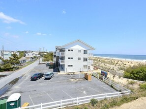 Ein Gebäude direkt am Strand mit Parkplatz, Blick auf den Strand und einem Schild mit der Aufschrift 'TANNE'S'.