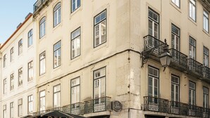 A multi-story building with balconies, a café, and outdoor seating. - Esqina Apartments (Lisbon)