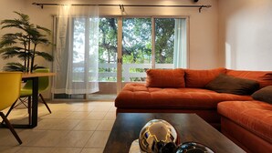Un salon moderne avec un canapé, une table basse et une plante en pot.