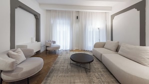 Una sala moderna con sofá, sillón y una mesa de centro redonda.