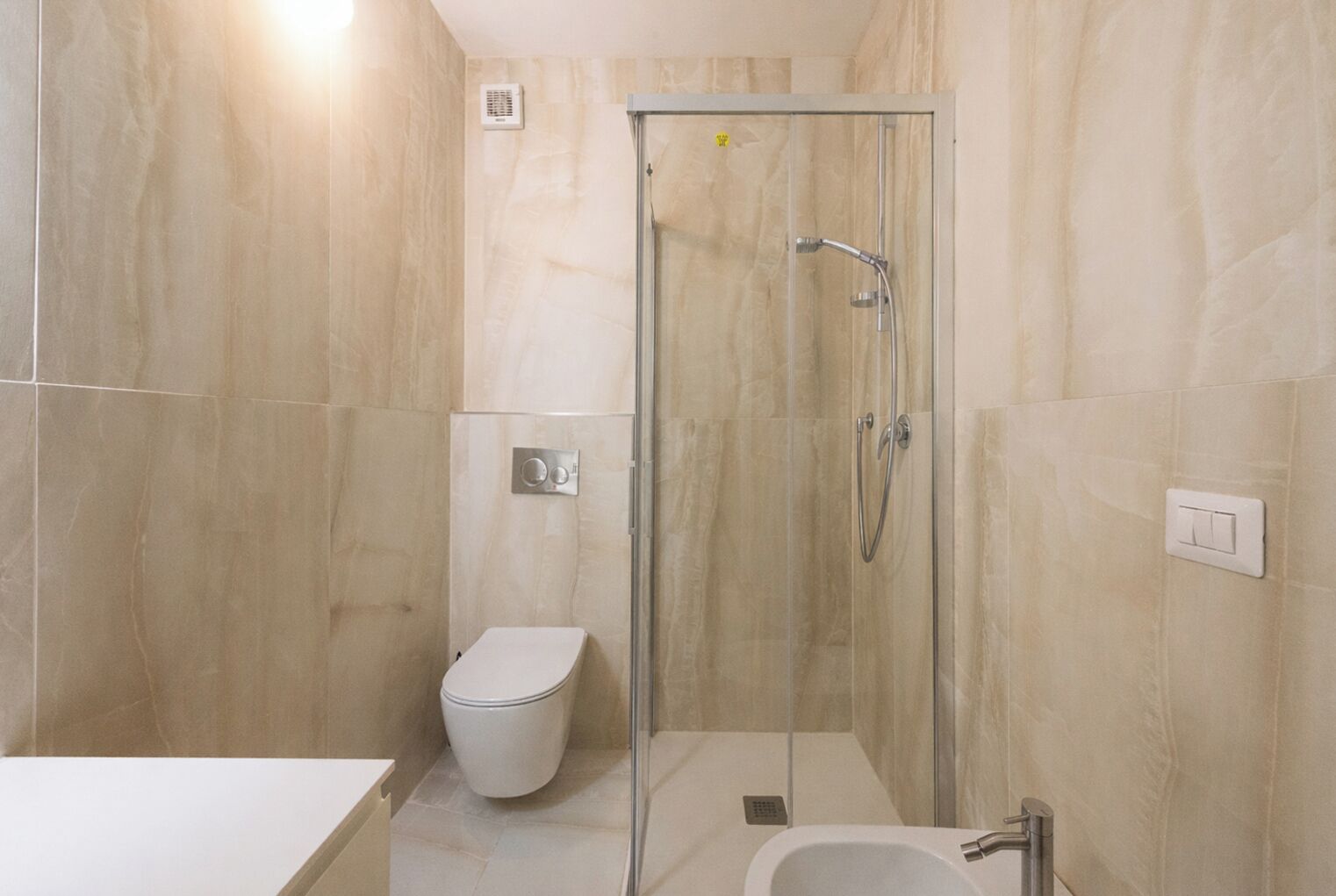 Ein modernes Badezimmer mit einer Duschkabine, einer Toilette und einem Waschbecken.