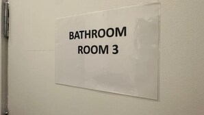 Un letrero en una puerta que dice 'BATHROOM ROOM 3'.