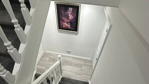 En trappa med vita trappräcken och en inramad tavla på väggen.