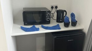 A compact kitchenette with a black microwave, a black coffee maker, and a black refrigerator. - Central London- Zone 1/2 En-suite Room (Greater London)