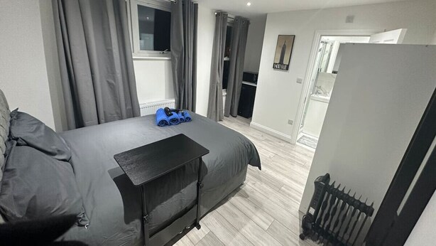 A modern bedroom with a large bed, a small desk, and a radiator. - London Waterloo 10mins away (Greater London)