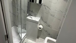 A modern bathroom with a glass shower enclosure, a sink, and a toilet. - London Waterloo 10mins away (Greater London)