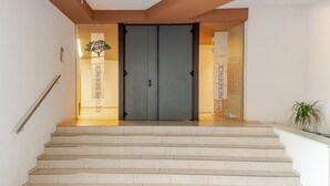 A staircase leading to a double door with a logo and the words "RESIDENCE" on the walls.