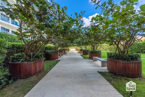 A pathway lined with wooden planters and trees, leading to a building with multiple windows. - ¡Oceanfront TopSpot® @ Cartagena´s Best Beach! (Cartagena de Indias)