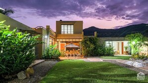 Uma casa moderna com um pátio, área de estar externa e vista para as montanhas.