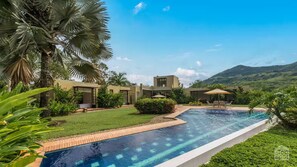 Un espace piscine moderne offrant une vue dégagée sur le paysage environnant, avec notamment une montagne en arrière-plan.