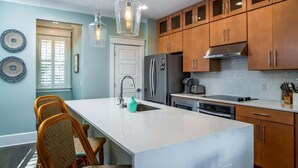 Una cucina moderna con mobili in legno, un'isola centrale e luci a sospensione.
