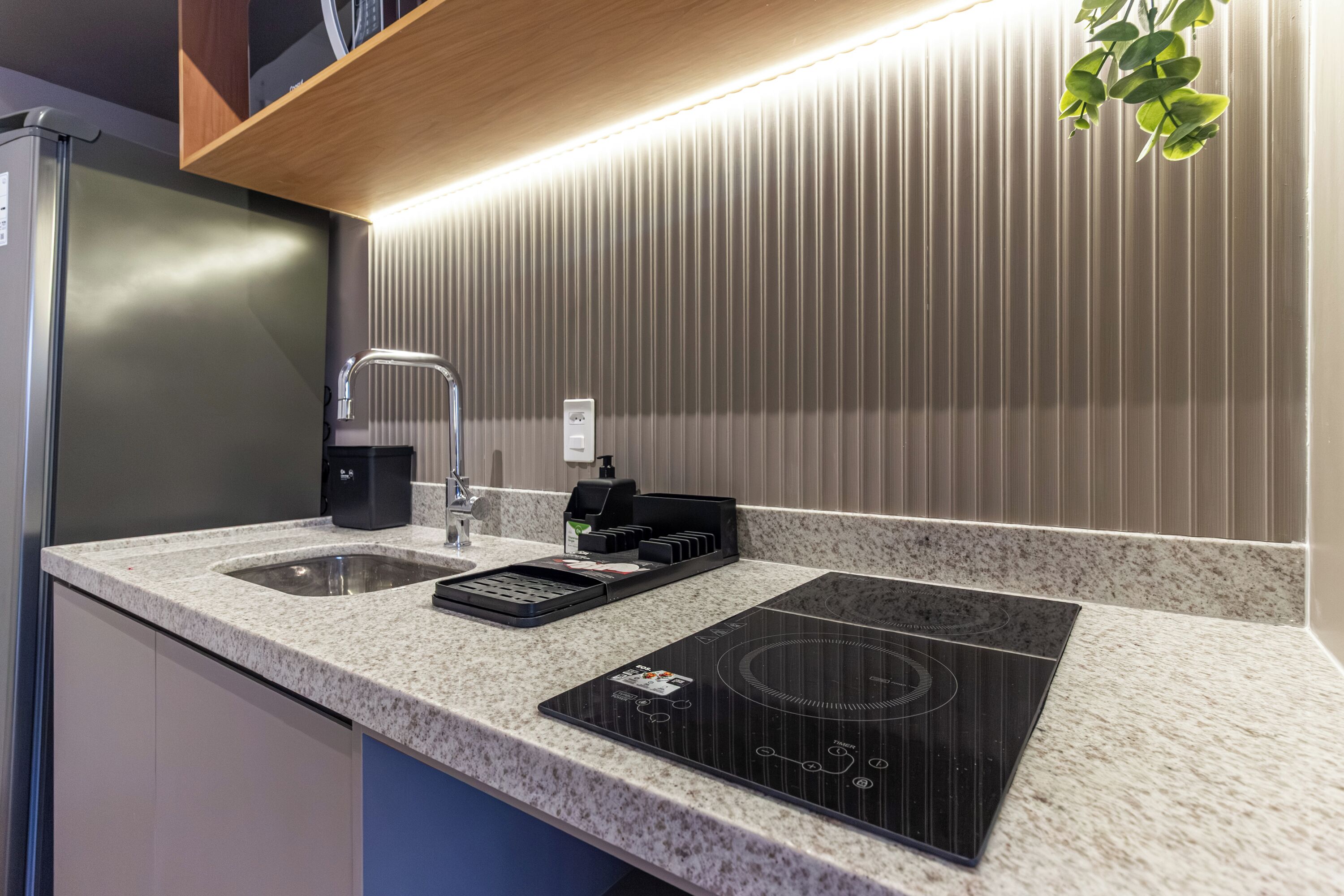 Una cocina moderna con encimera de granito, electrodomésticos de acero inoxidable, horno empotrado y salpicadero.