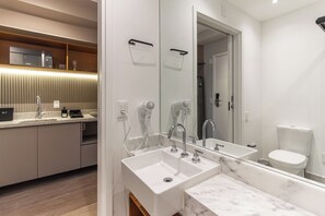 A modern bathroom with a large mirror, two sinks, a toilet, and a microwave above the sink. - 360 Latitude Campo Belo (São Paulo)