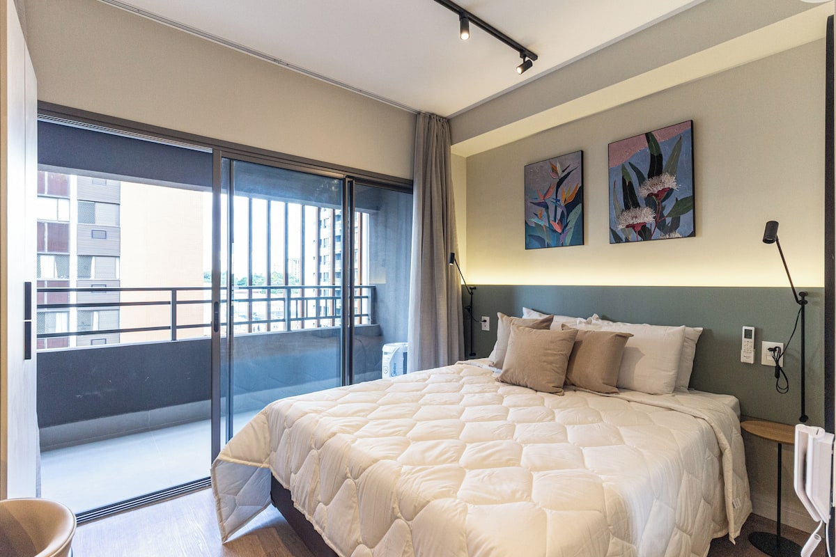 Un dormitorio con una cama grande, un balcón y dos obras de arte colgadas en la pared.