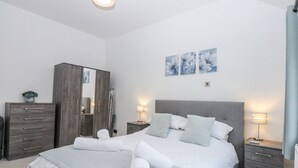 Une chambre à coucher moderne avec un grand lit, une armoire et une table de chevet.