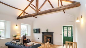 Ein Wohnzimmer mit einer Couch, einem Holztisch und einem Kamin.