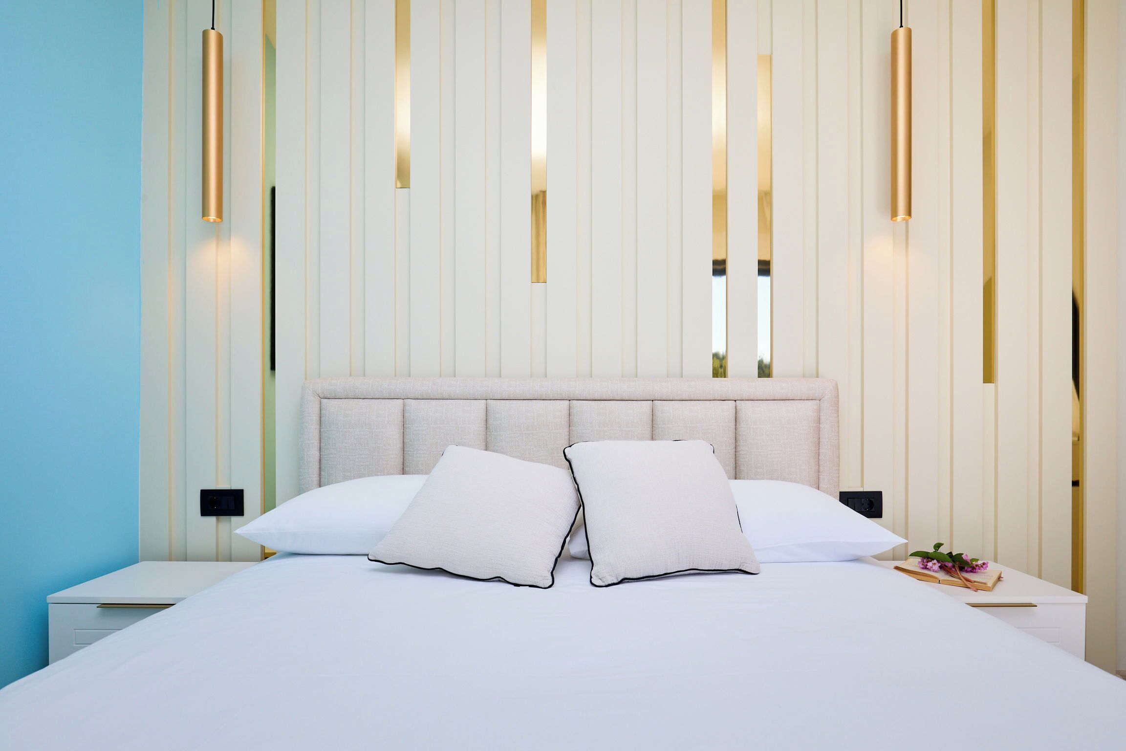 A modern bedroom with a large bed, two bedside tables, and a headboard.