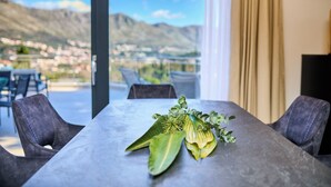 Una mesa de comedor con vistas a montañas y una ciudad al fondo.