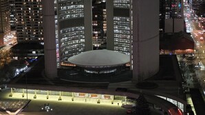 Een nachtzicht van een groot, modern gebouw met een centrale koepel en meerdere hoge torens.