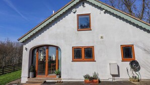 A white building with a pitched roof, a large arched entrance, and a small window. - Brush and Boot (York)