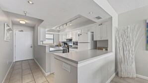 Una cocina moderna con armarios blancos, una isla central y un horno empotrado.