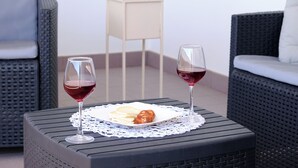 Ein Esstisch mit zwei Weingläsern und einer Speisenplatte.
