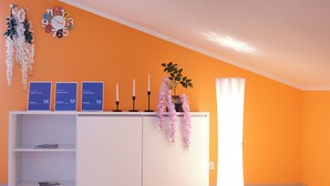 Ein Empfangsbereich mit einem weißen Schreibtisch, einer Uhr und einer hohen Stehlampe.