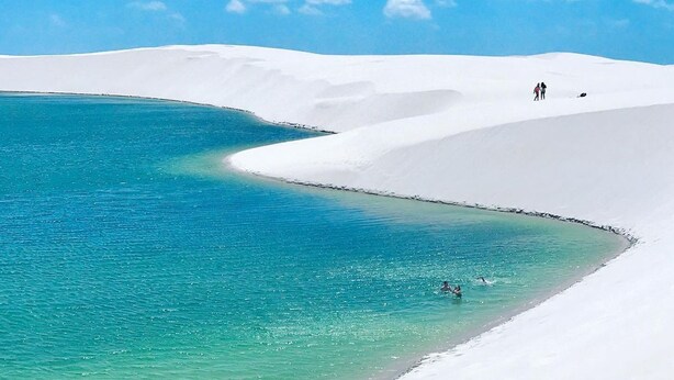 Una spiaggia con sabbia bianca e acqua turchese.
