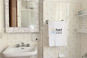 A bathroom with a sink, mirror, towel rack, and a decorative tile pattern. - SE223 - Senigallia, one-bedroom apartment near the beach (Senigallia)