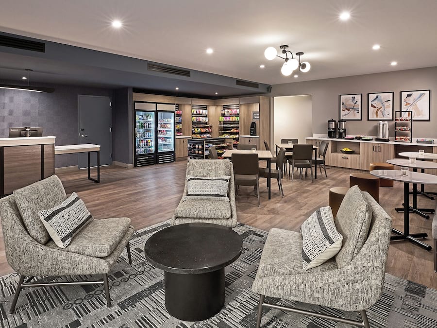 A modern lounge area with seating, a coffee station, and a snack bar.
