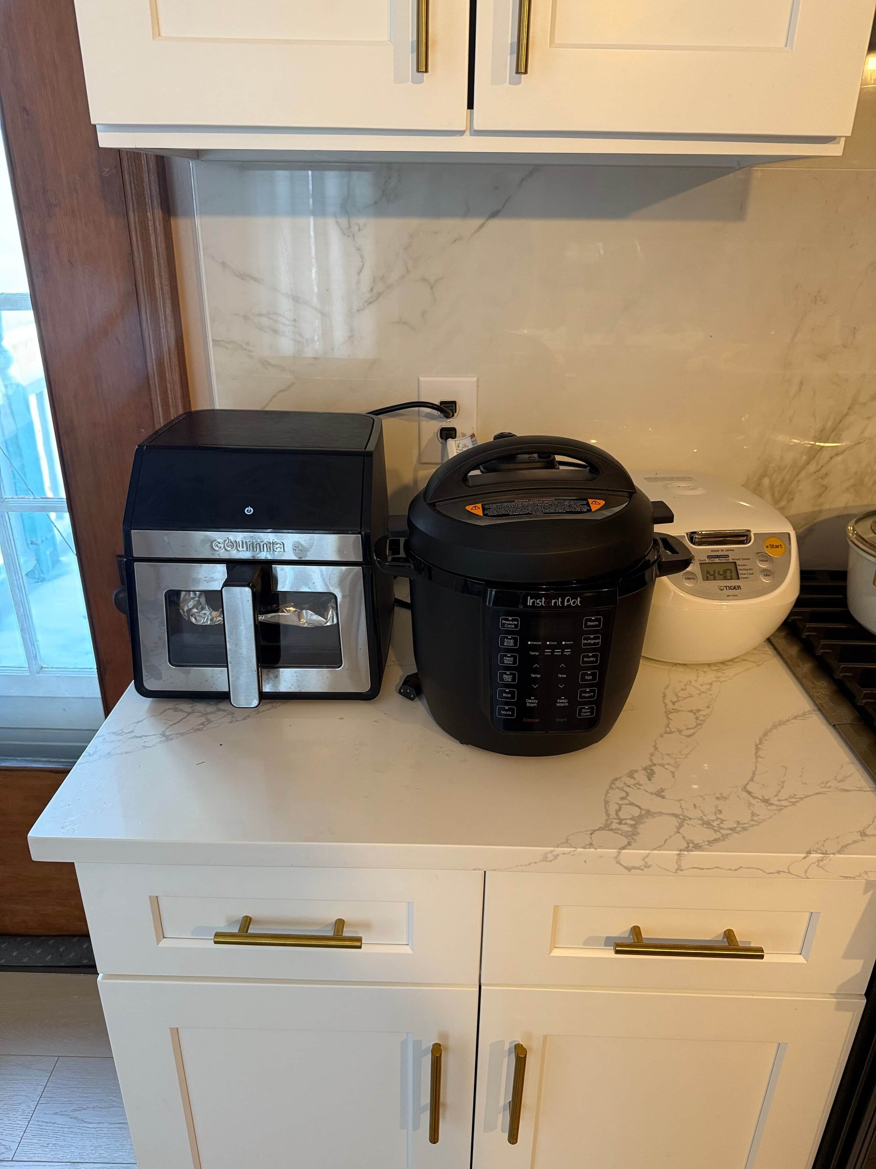 A kitchen with a countertop, a coffee maker, a rice cooker, and a toaster.