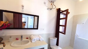 A bathroom with a sink, mirror, toilet, and shower. - Thami House Watamu (Watamu)