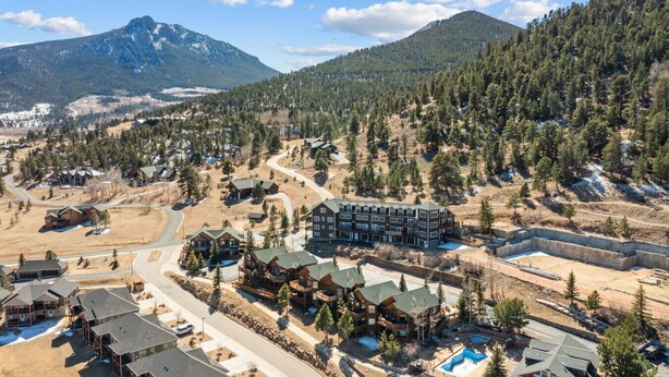 A resort with multiple lodge-style buildings, a swimming pool, and a mountainous backdrop. - Estes Park Retreat | 2 Kings | Near RMNP | ADA Friendly (Estes Park)
