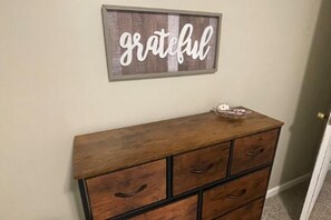 Eine hölzerne Kommode mit Schubladen und einem Schild darüber, auf dem 'grateful' steht.