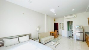A hotel room with a bed, a sofa, a dining table, and a kitchen area. - Stay Central-Prestige Address &Private Comfort. (Thành phố Hồ Chí Minh)