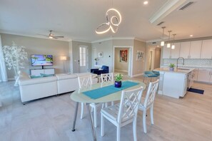 Un salon moderne avec un canapé, un téléviseur et un coin repas.